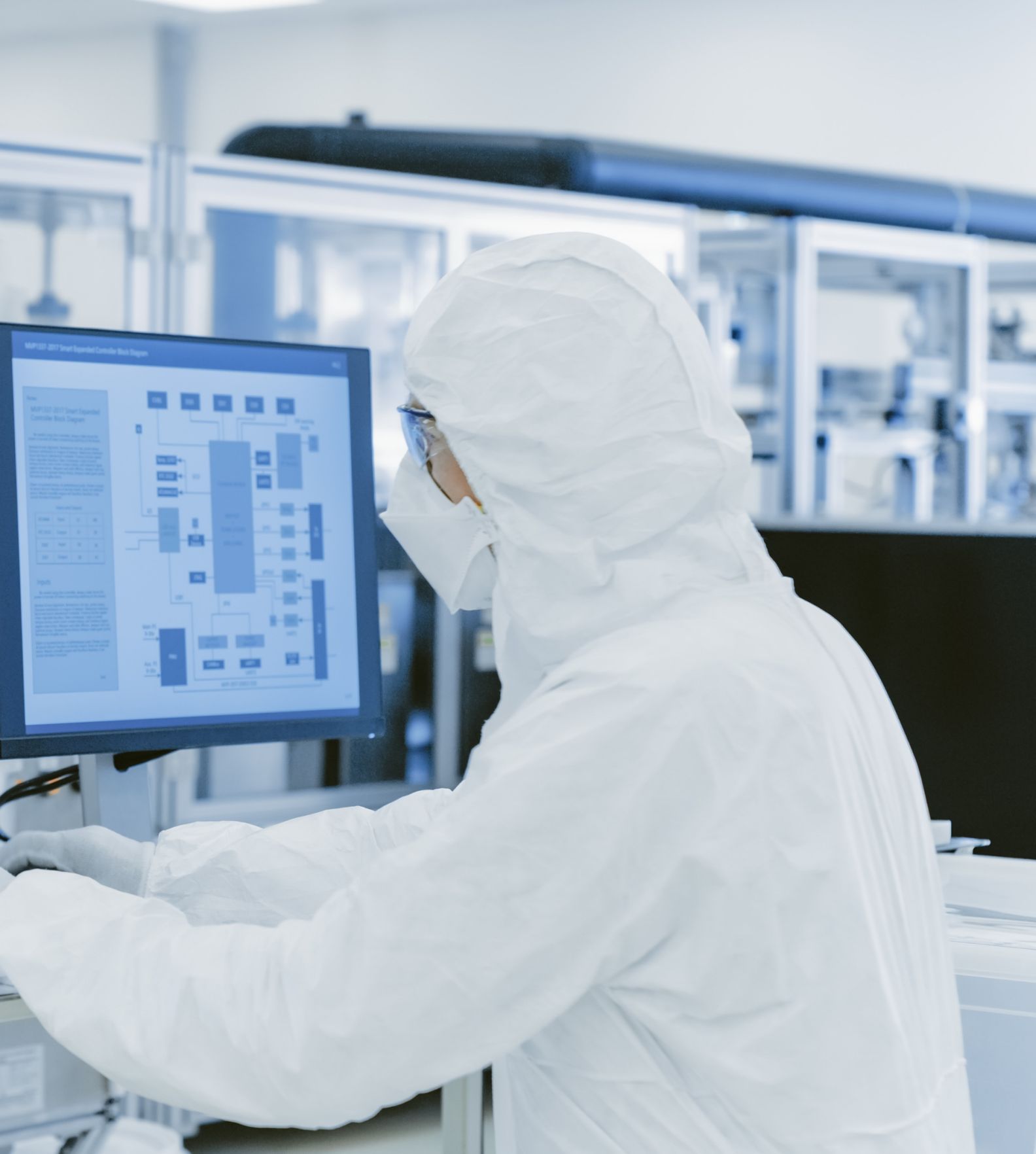 Man working at computer in a clean room setting