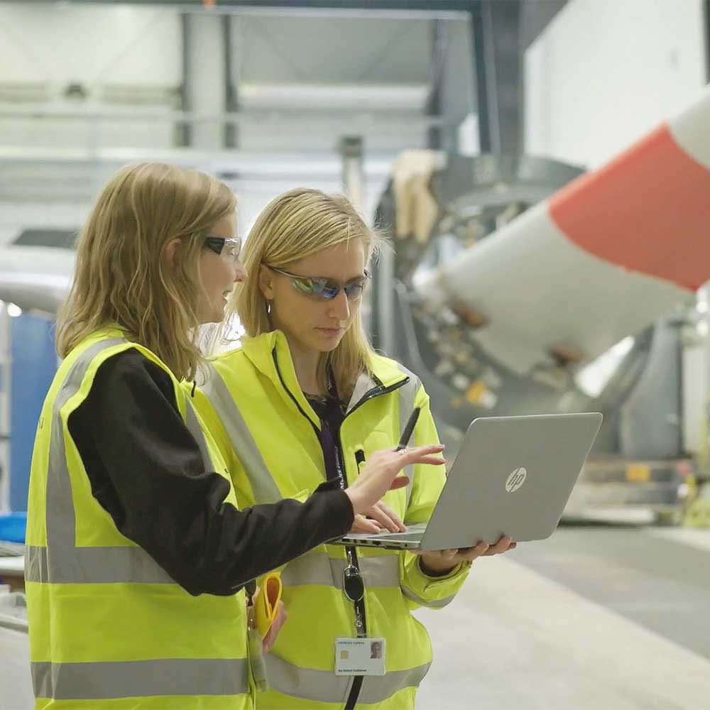 两名工人在叶片工厂带着笔记本电脑磋商