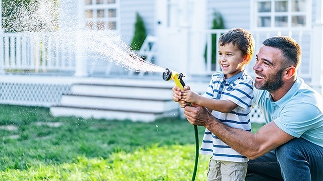 father splashing water and having fun with son