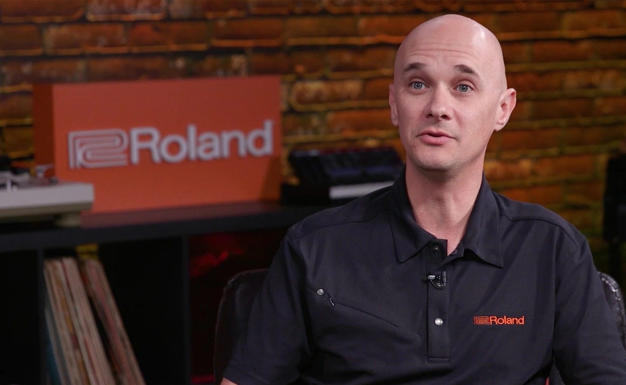 Pessoa falando em frente ao logotipo da Roland
