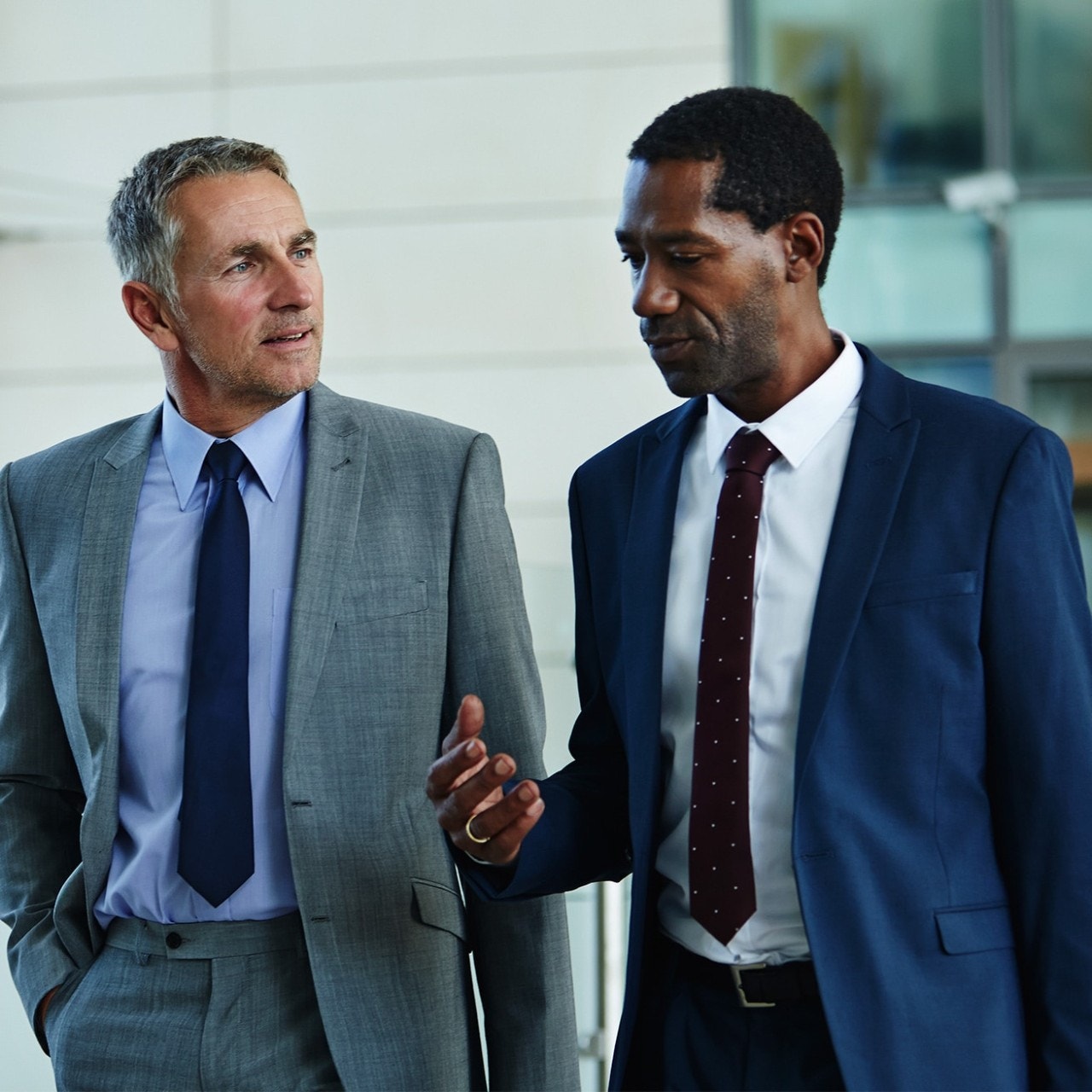 Two people walking in suits
