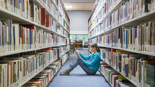 Student Reading on the Floor in a College Library