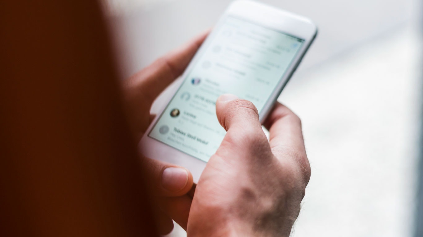 Personne tenant un smartphone regardant ses messages