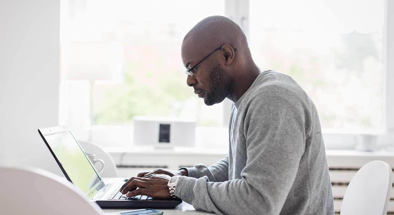 Person uses laptop computer while sitting at desk