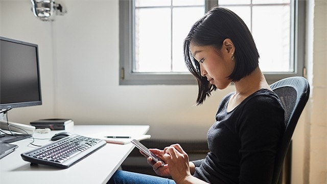 Young woman using smartphone at work