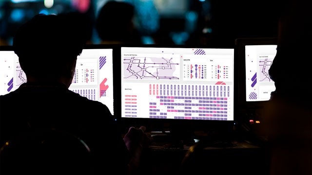 Rear silhouette view of man looking at computer screen with SPOO planning app on it