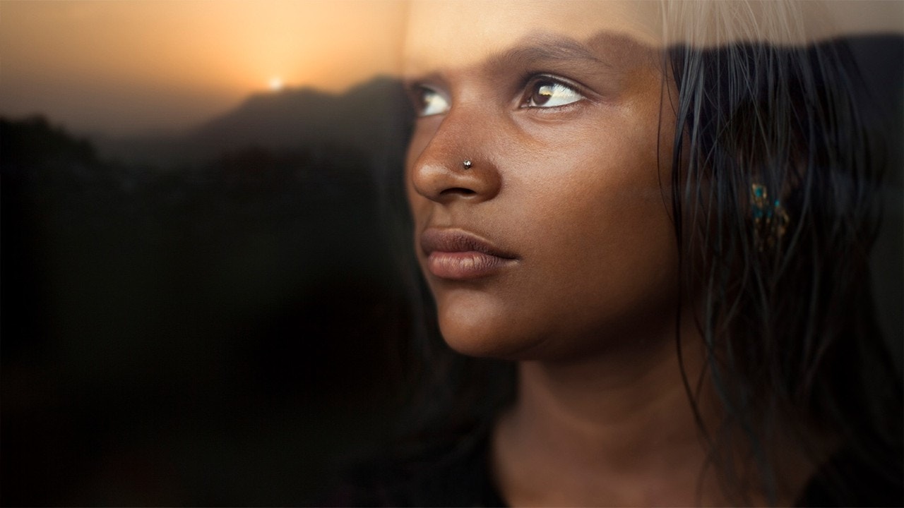 Tampilan jarak dekat dari seorang wanita dengan matahari di belakangnya