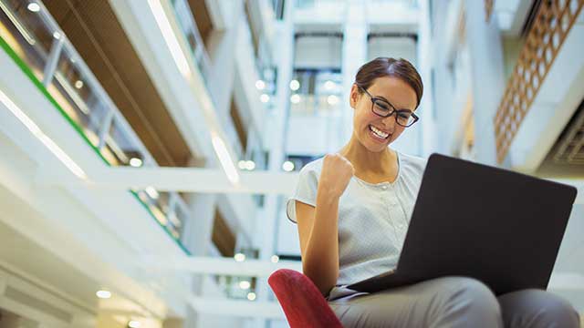 una donna d'affari entusiasta davanti a un laptop