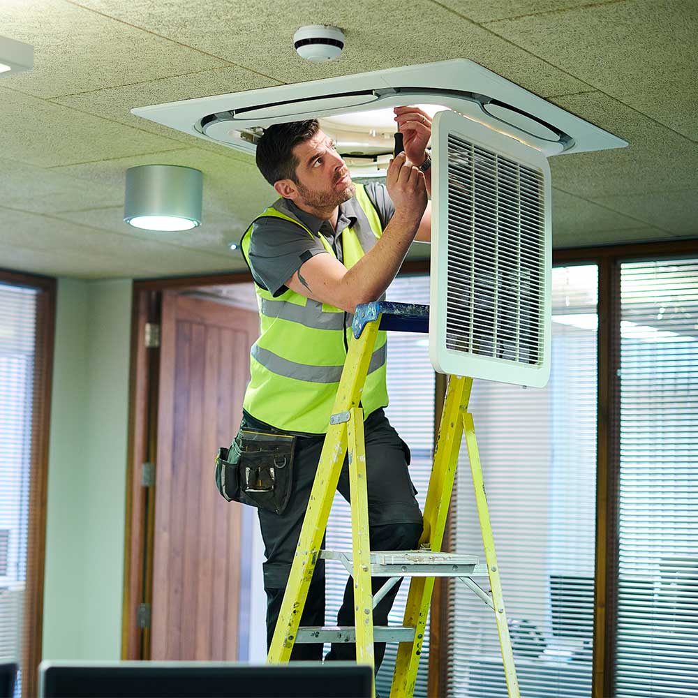 Un addetto alla manutenzione dei condizionatori