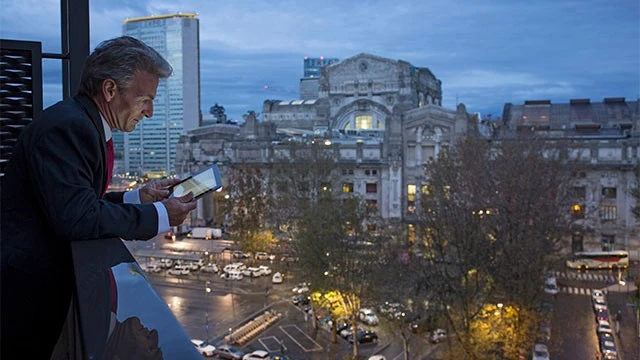 Businessman uses digital tablet in city twilight
