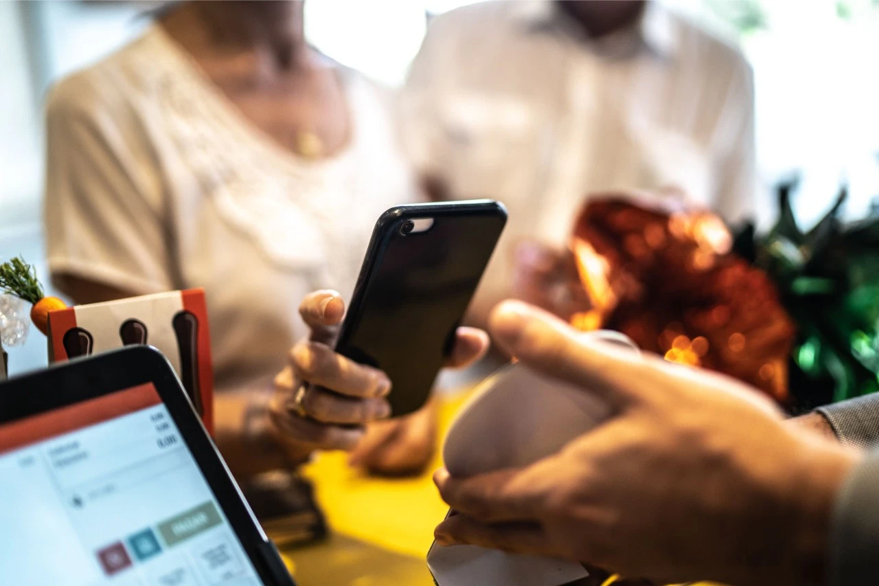 Mujer pagando con el móvil en una tienda
