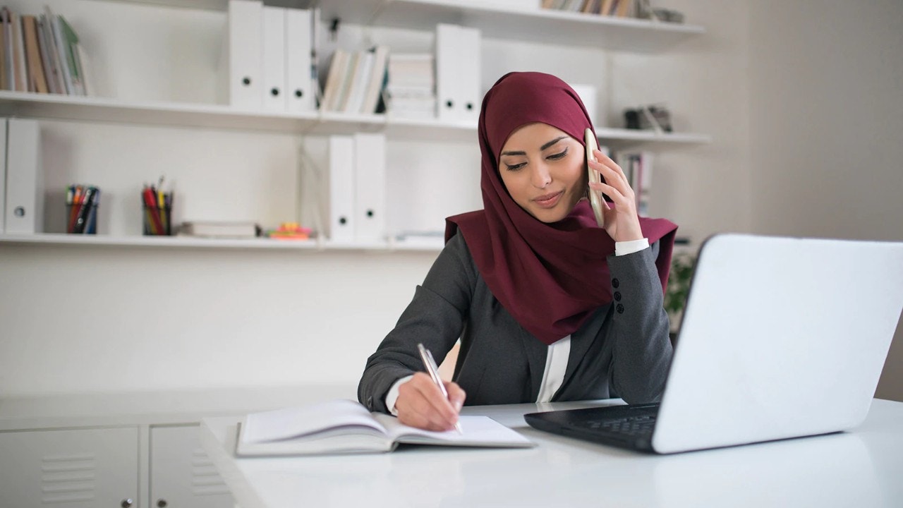 Persona usando su teléfono móvil y escribiendo notas