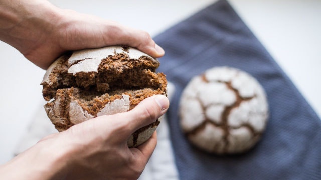La main d'un boulanger rompant le pain