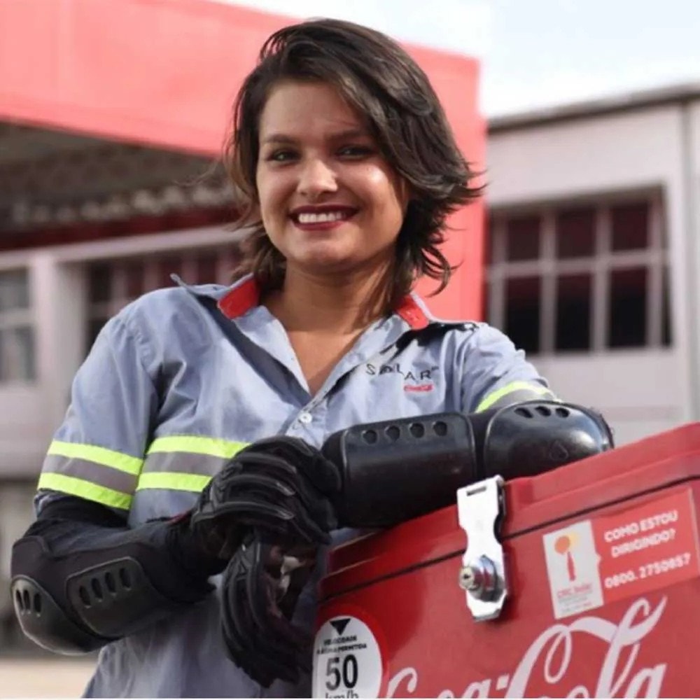Femme en uniforme Solar près d’une glacière Coca-Cola