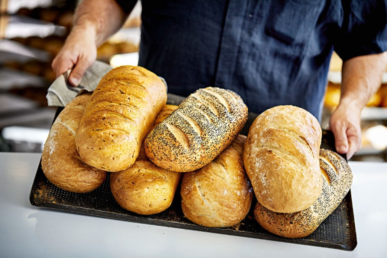 Boulanger transportant des pains sur un plateau