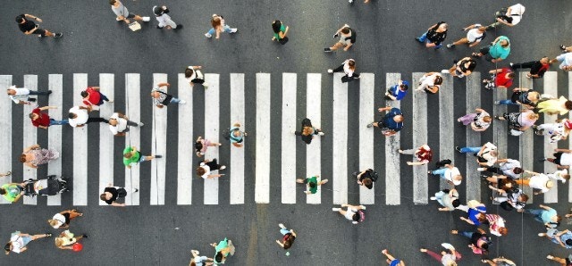 Calle concurrida con mucha gente cruzando el paso de peatones