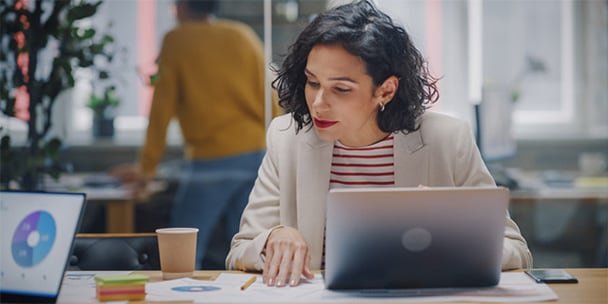 Person sitting at desk in office working on laptop