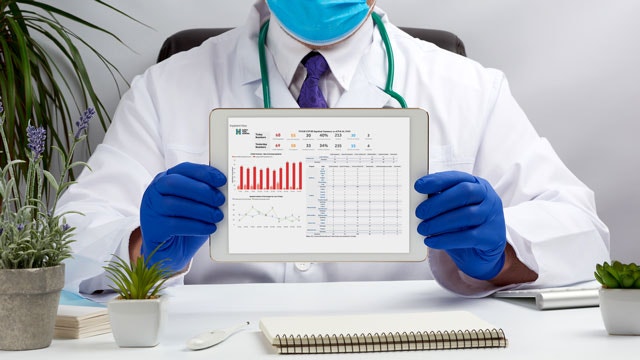 Dokter yang sedang memegang tablet digital yang menunjukkan dasbor COVID-19 NYGH