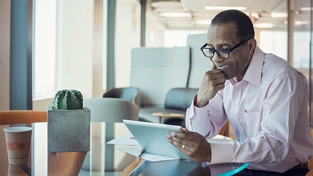 Executivo trabalhando sozinho no escritório usando tablet digital