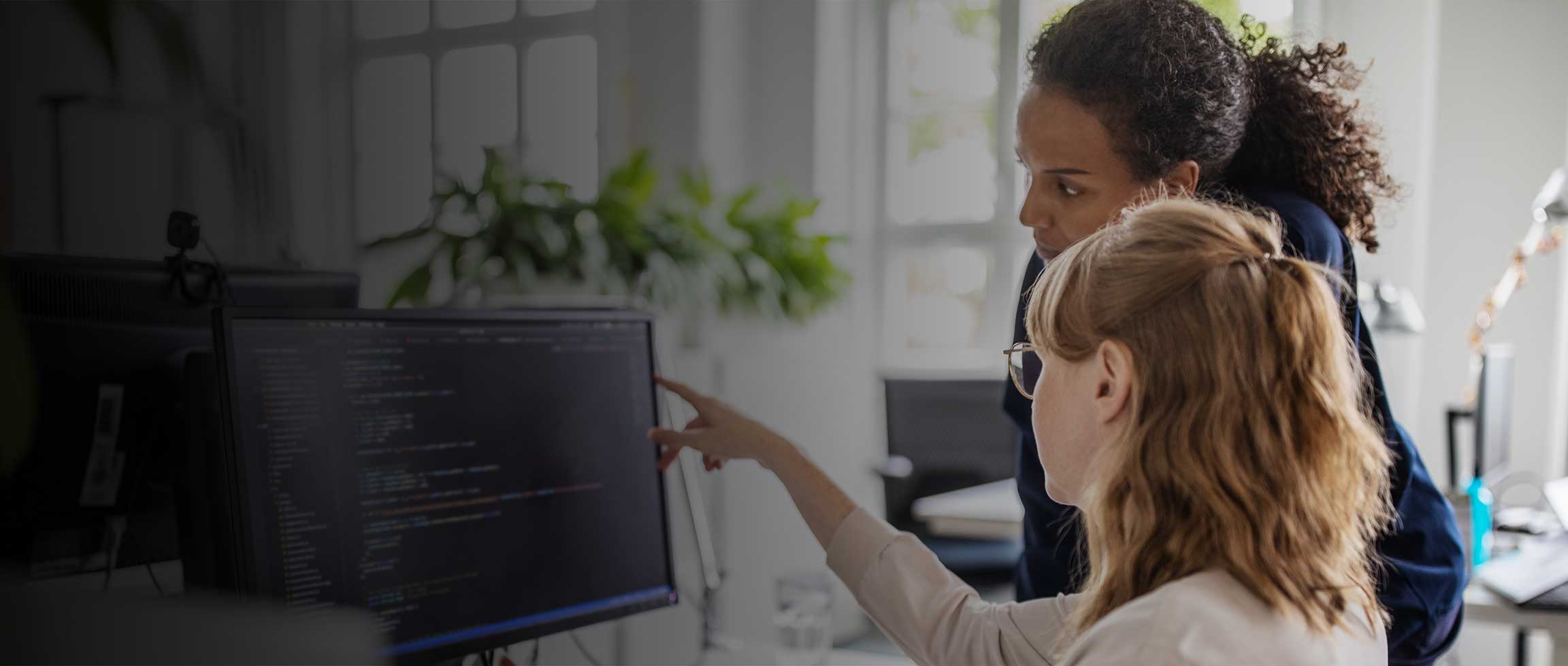 Coworkers discussing computer program in office