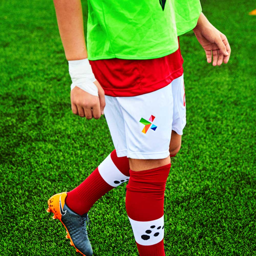 Jóvenes de fútbol vistiendo pantalones cortos Norsk Tipping