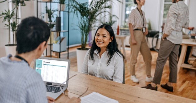 Female employee giving interview with HR manager leading talent acquisition.