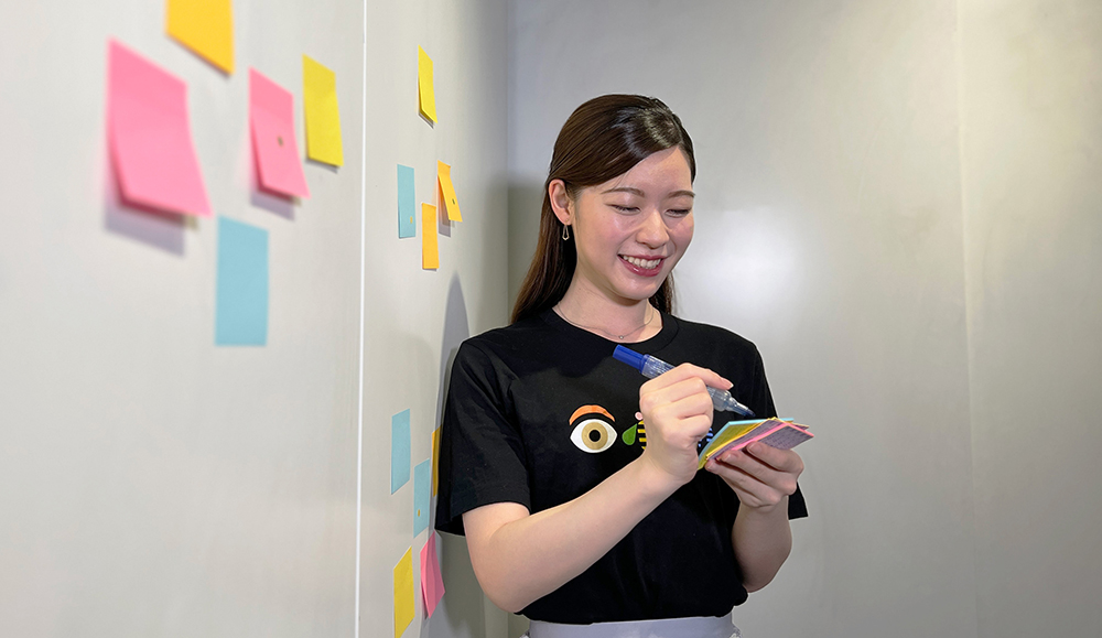 woman writing on sticky notes during a design workshop in Japan