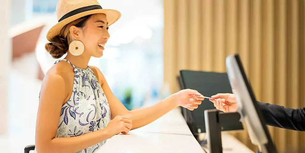 woman giving card to hotel front desk