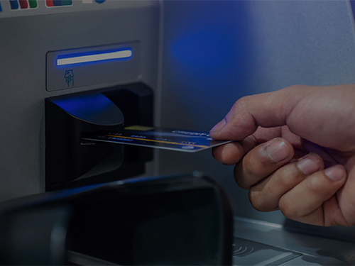 Pessoa colocando seu cartão de banco em uma máquina ATM
