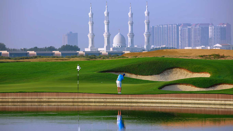 Golf course with a middle eastern city in the background