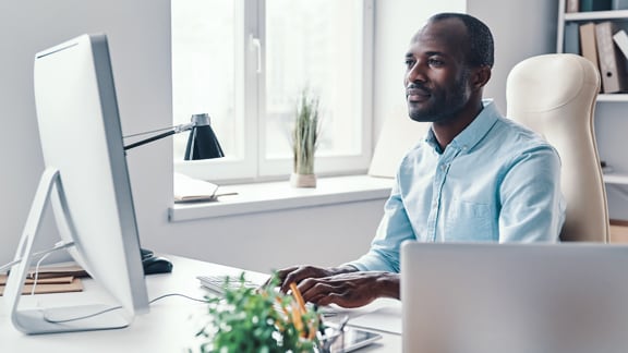 Office worker at a desk, using a desktop PC