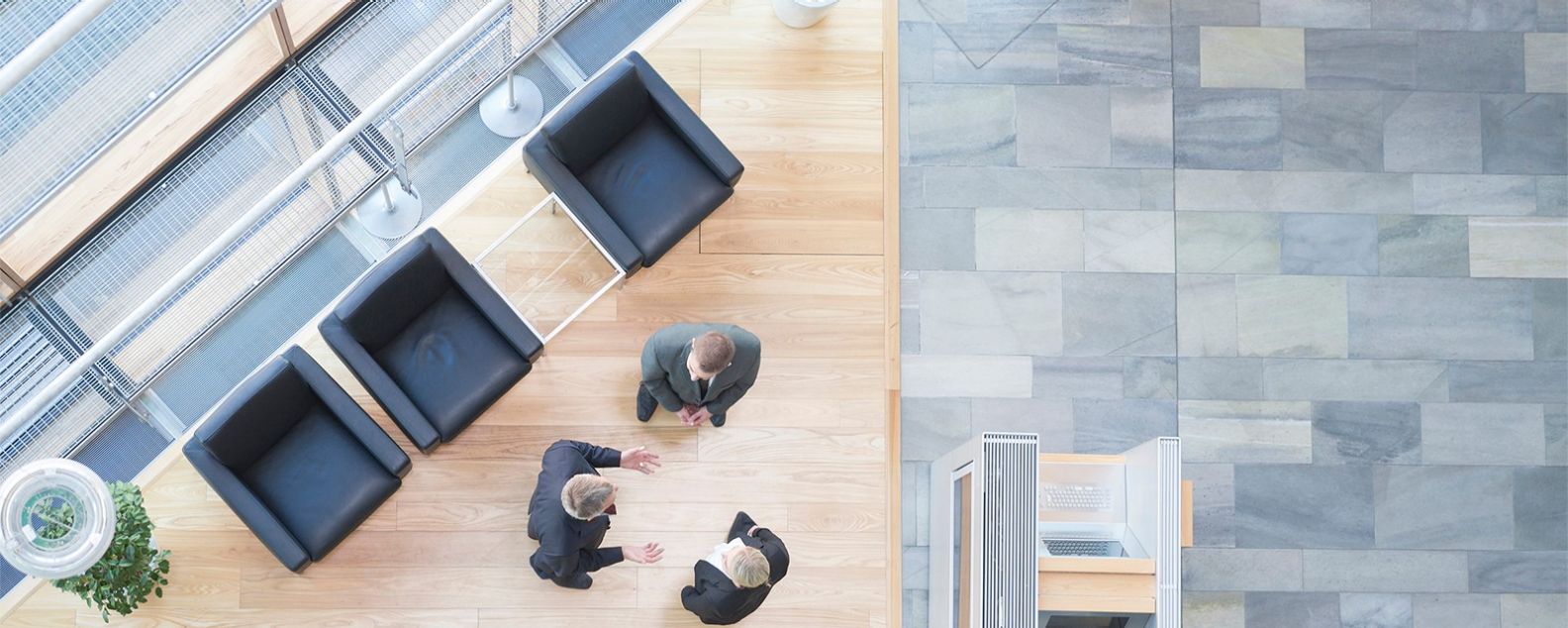 Tres empresarios hablando en el vestíbulo de un edificio de oficinas