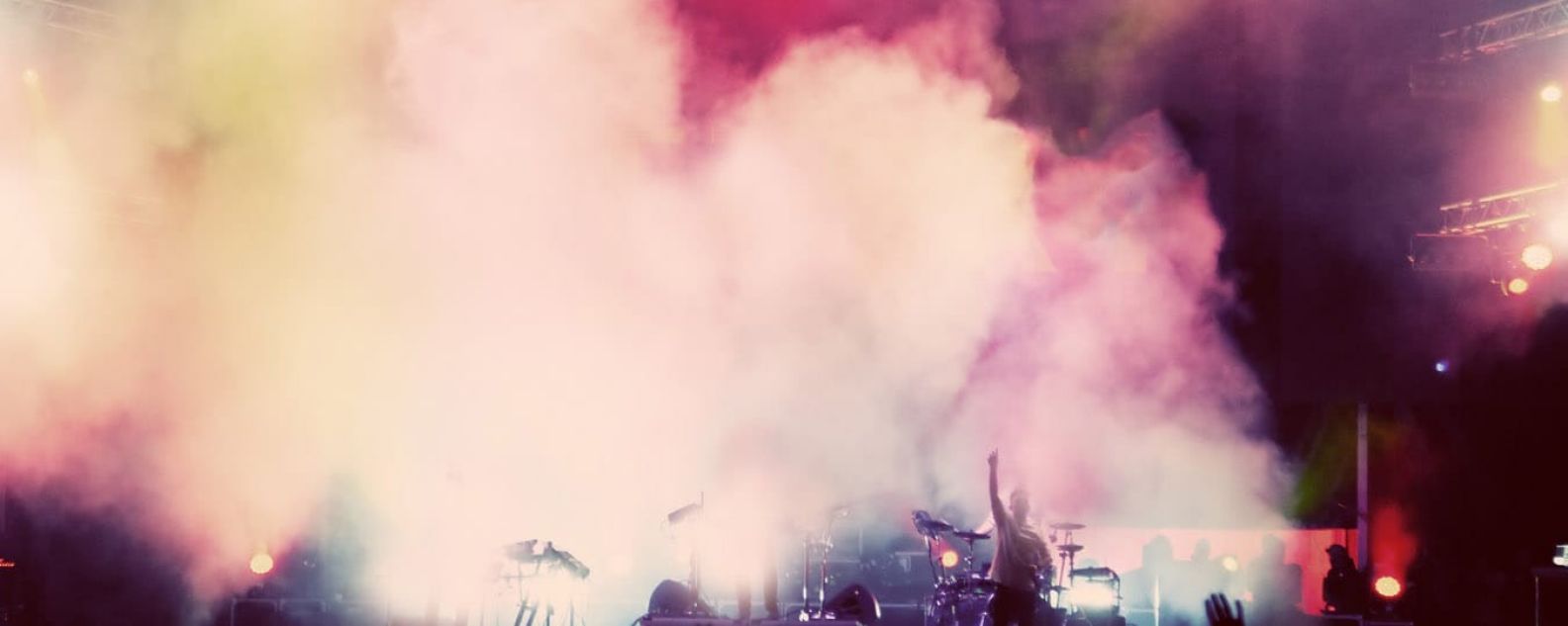 Band on stage at concert with smoke effects surrounding them