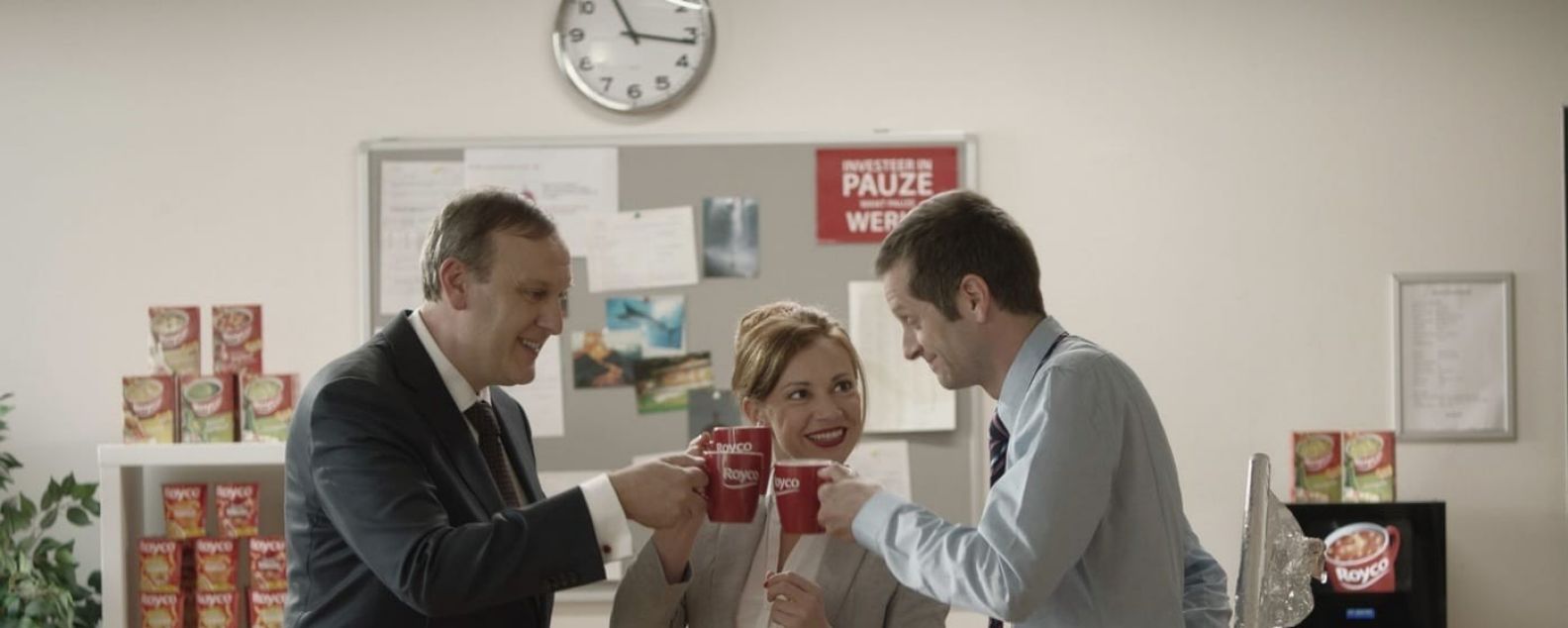 Three office workers toasting with coffee cups