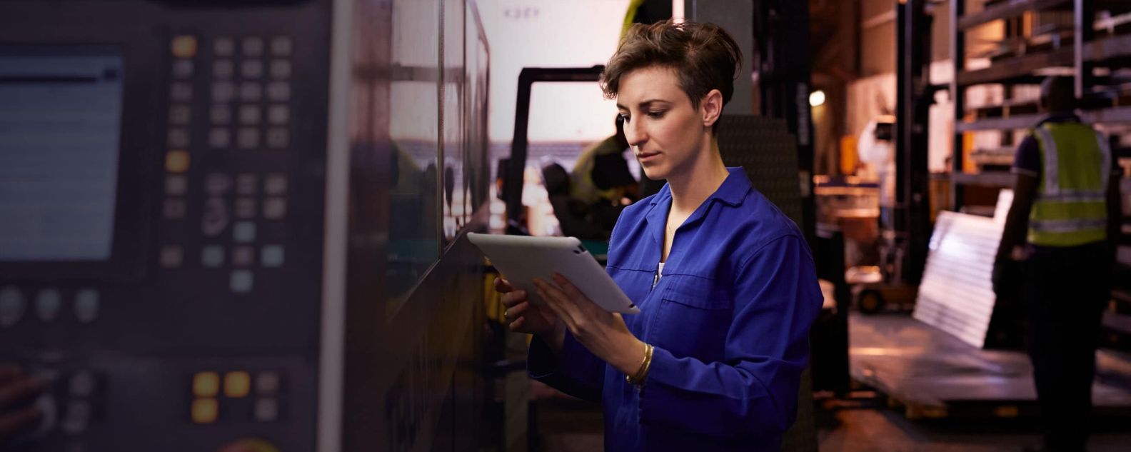 Mujer mirando un ordenador portátil en una fábrica