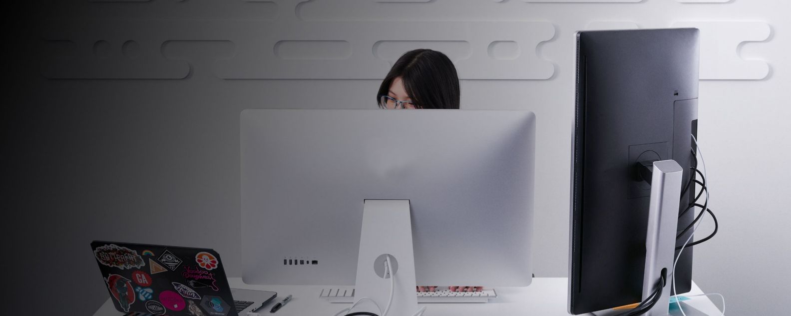 Wanita yang bekerja terkonsentrasi di depan monitor laptop