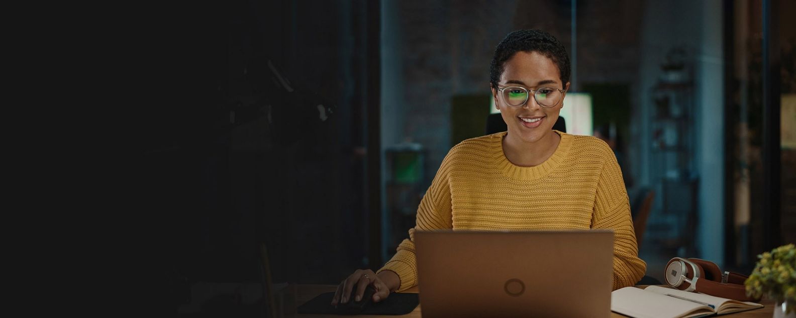 wanita menggunakan laptop dan tersenyum