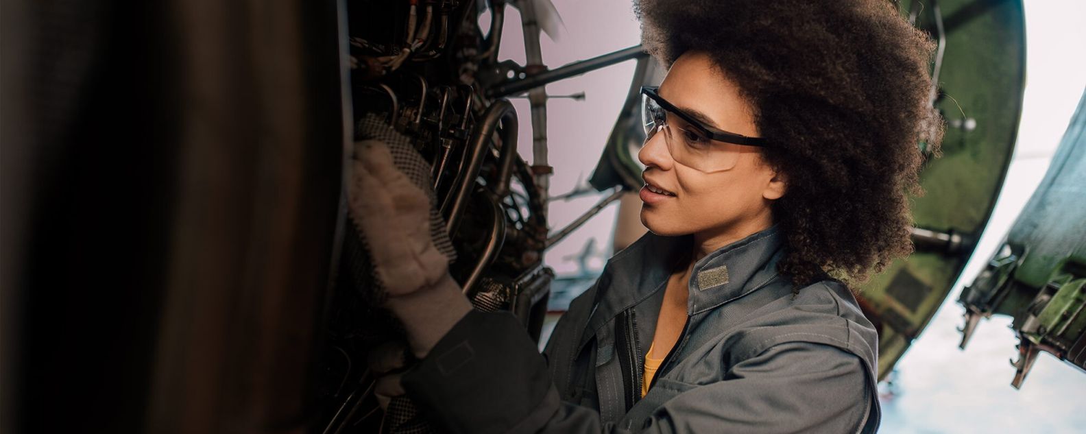 Persona con gafas de seguridad trabajando en un sistema mecánico grande