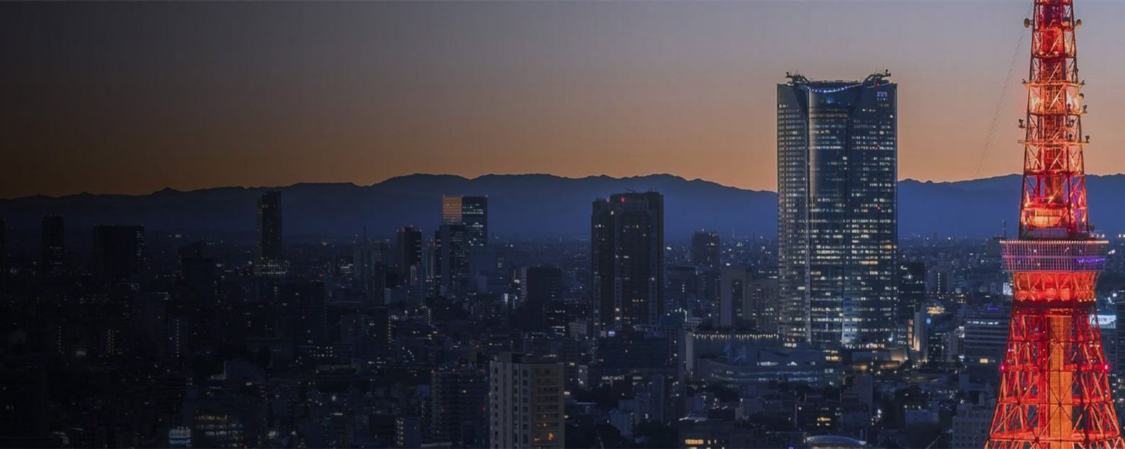 Gedung pencakar langit Tokyo yang gemerlapan berlatar cakrawala di malam hari