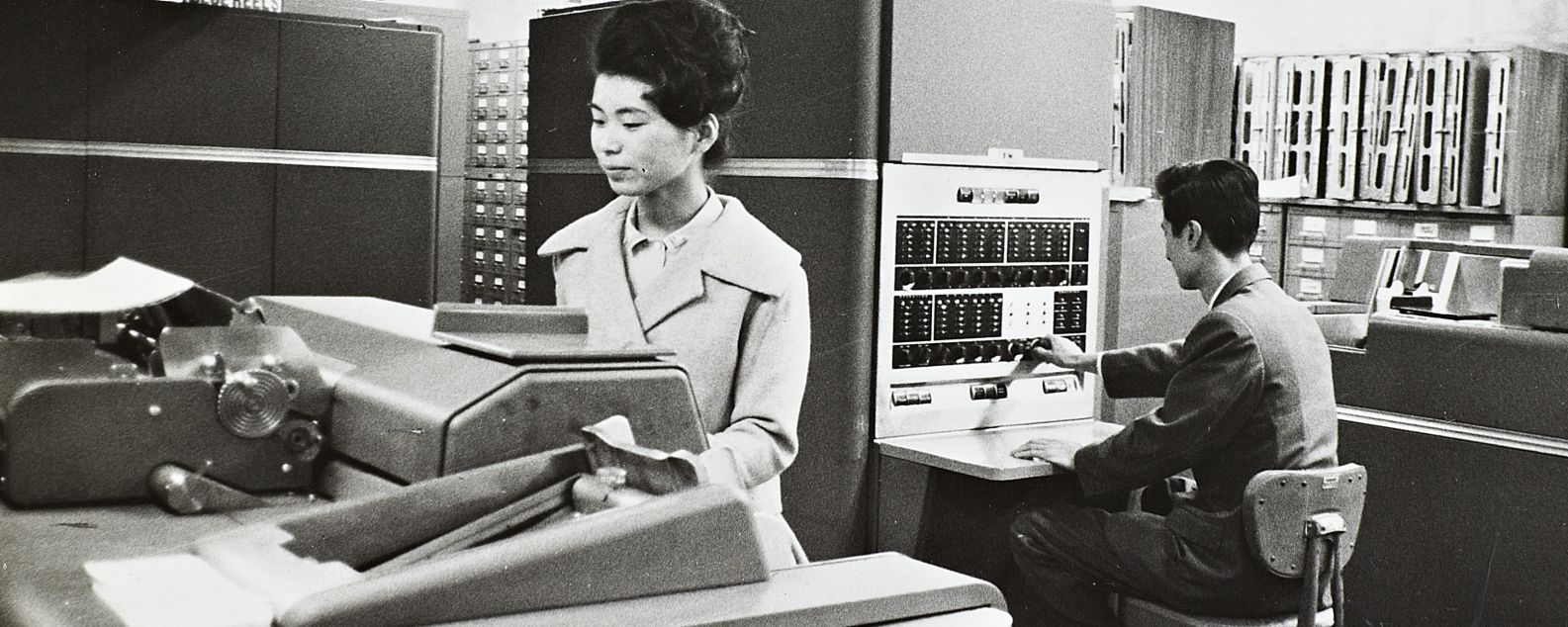 A man and woman working in a computer room