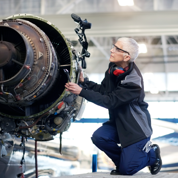 Técnico inspeccionando un motor de reacción en un hangar 