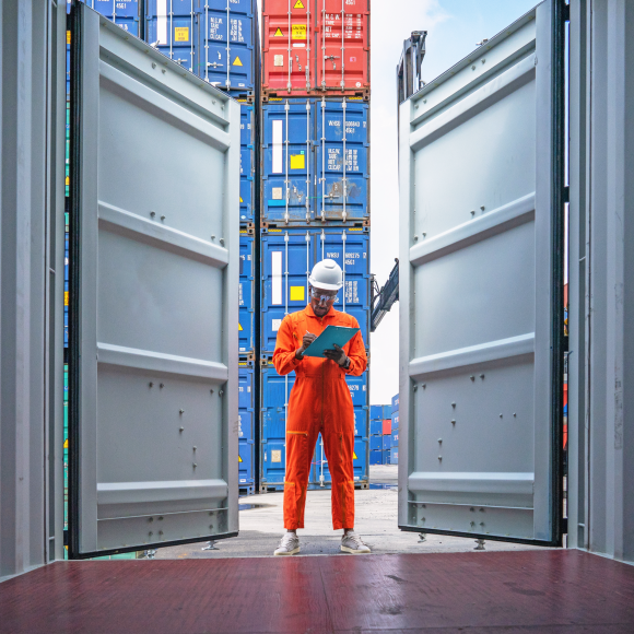 Pekerja memeriksa inventaris dalam kontainer pengiriman