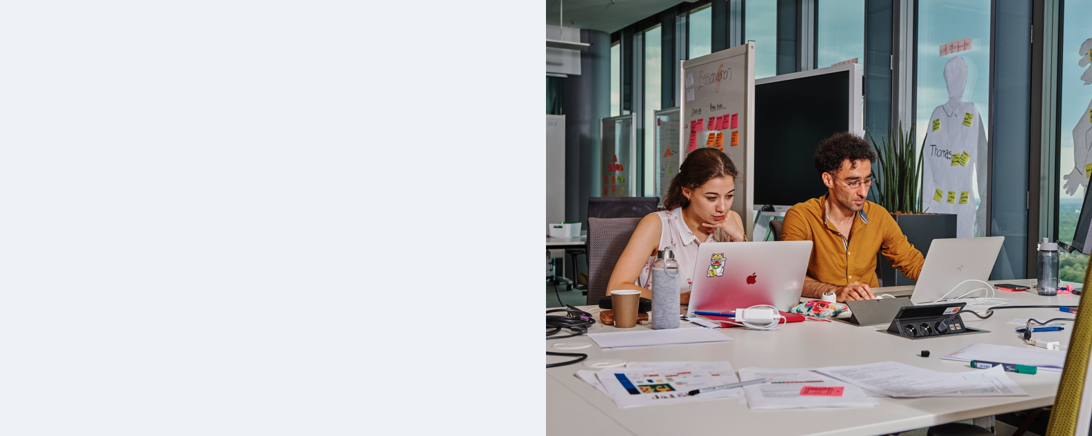 Dos personas sentadas en un escritorio de oficina en un taller de design thinking