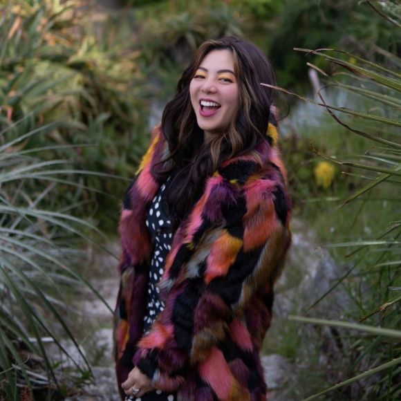 Happy IBM employee surrounded by nature wearing colorful clothes