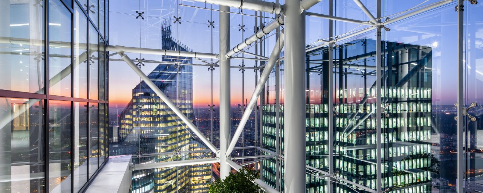 Foto de vista de la ciudad desde un edificio con estructura de vigas interconectadas y vidrio