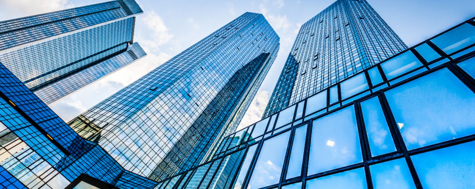 푸른 하늘을 배경으로 업무 지구에 있는 현대적인 고층 건물의 올려다 본 모습