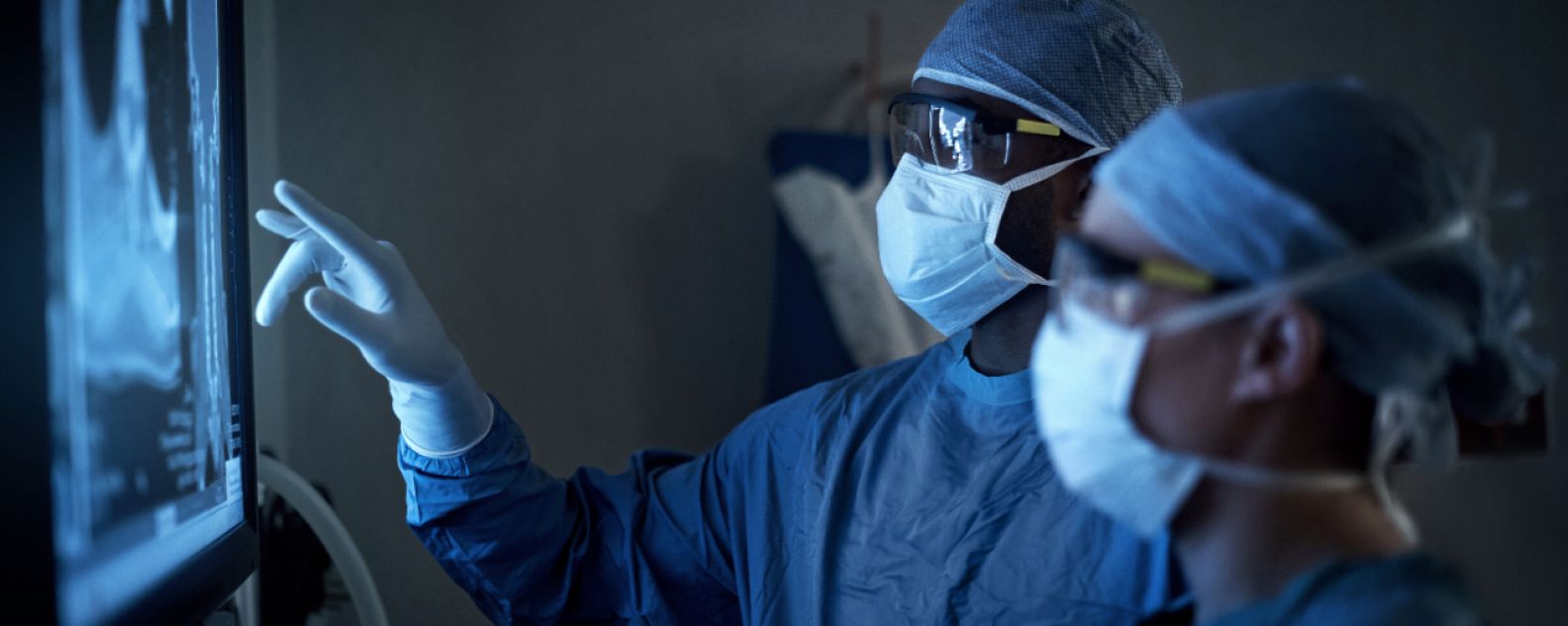 Photo de deux chirurgiens analysant les scanners médicaux d'un patient pendant une opération chirurgicale