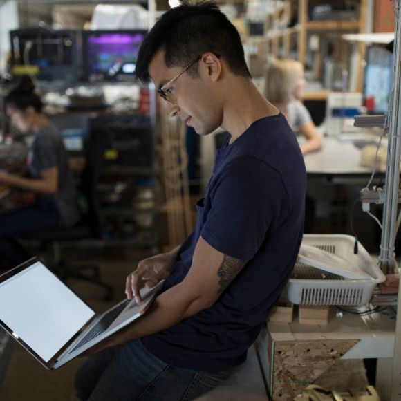 Male engineer working at laptop in workshop