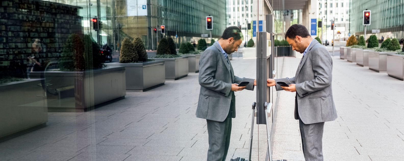 London, UK, businessman taking money at an ATM in the city