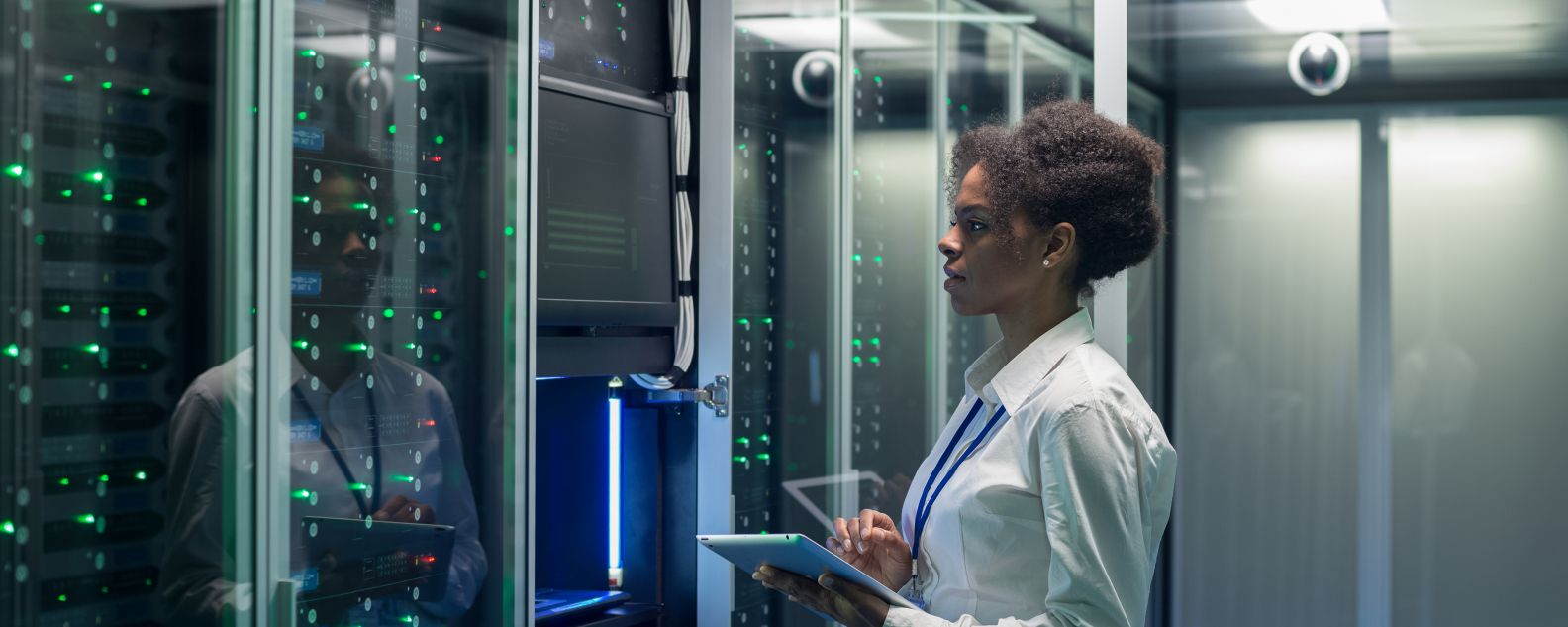 Female technician works on a tablet in a data center